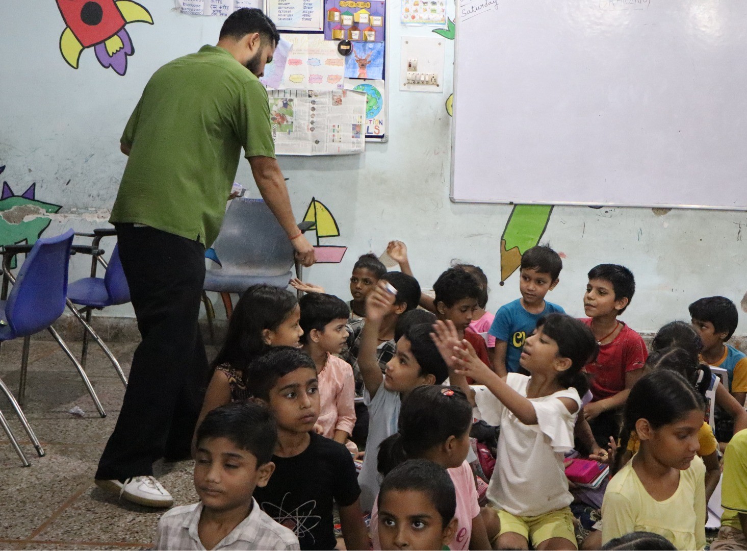 A person is distributing stationery item to kids